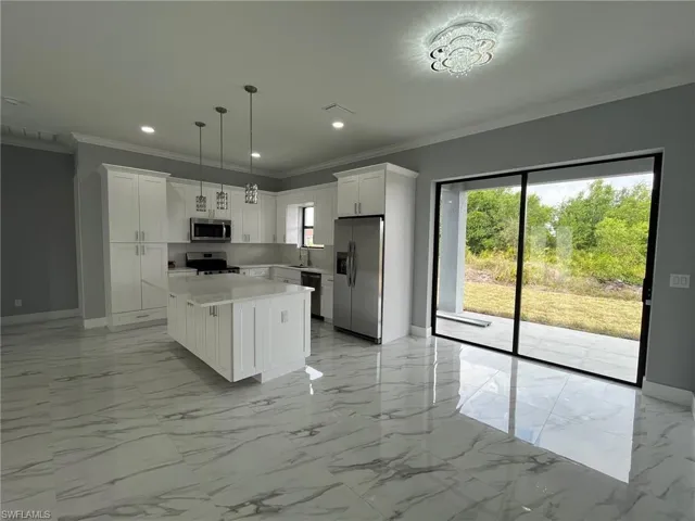 Kitchen with marble finish floor, stainless steel appliances, a sink, and white cabinets