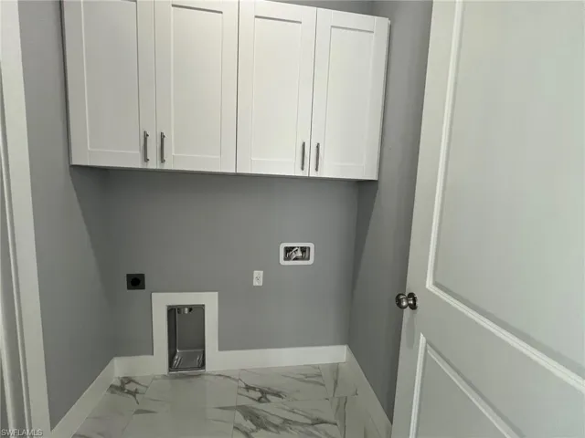 Washroom featuring washer hookup, marble finish floor, cabinet space, electric dryer hookup, and baseboards