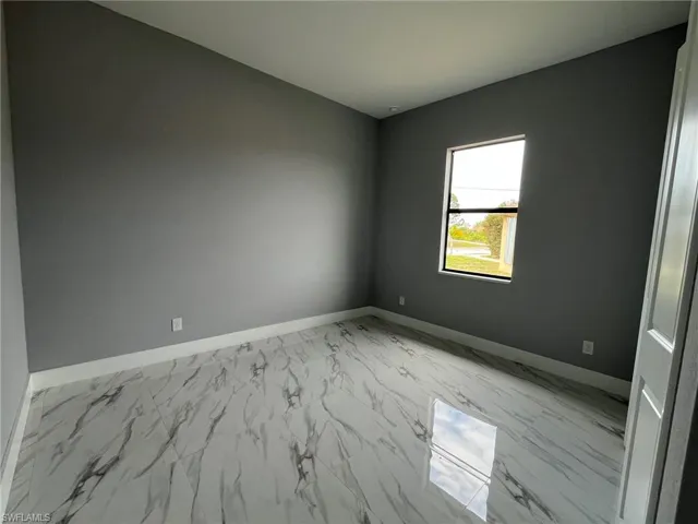 Unfurnished room with marble finish floor and baseboards
