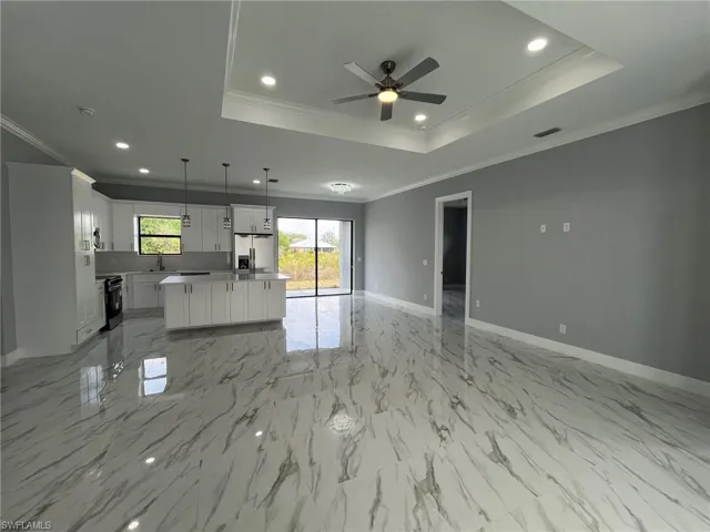 Kitchen with a sink, visible vents, open floor plan, stainless steel fridge with ice dispenser, and a raised ceiling