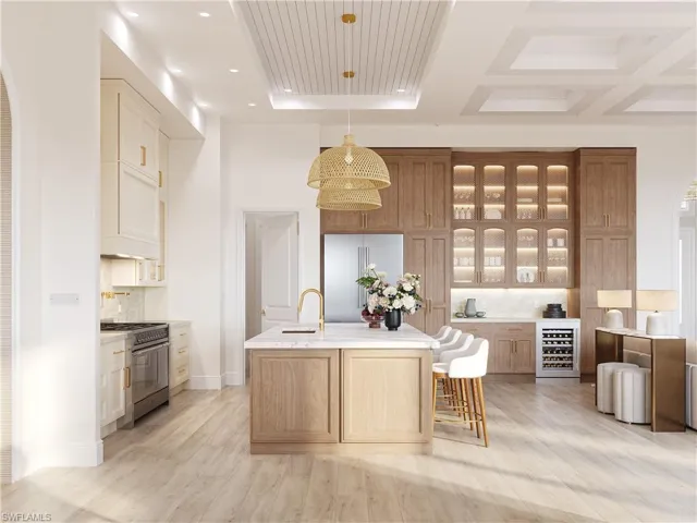 Kitchen with glass fronted cabinets, arched walkways, a breakfast bar area, an island with sink, and beverage cooler
