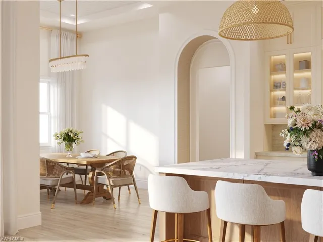 Dining room with light wood-style floors and arched walkways
