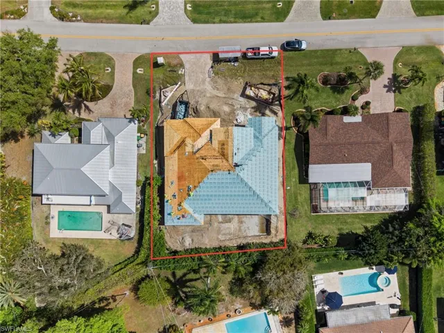 Aerial view of property and surrounding area featuring property parcel outlined and a pool