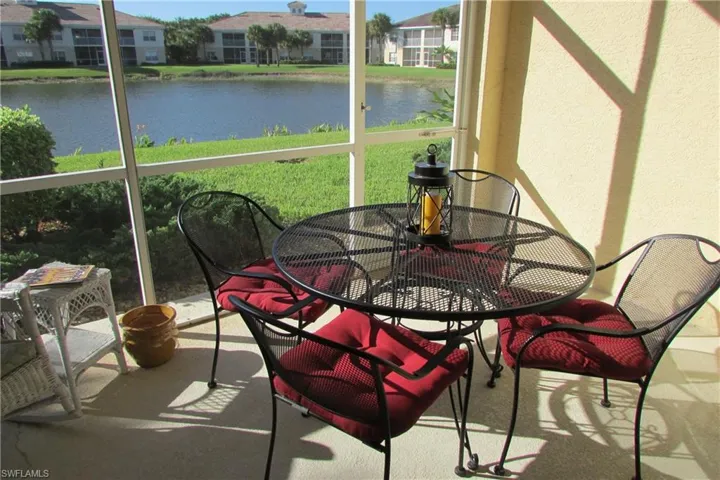 Sunroom with a water view and outdoor dining area