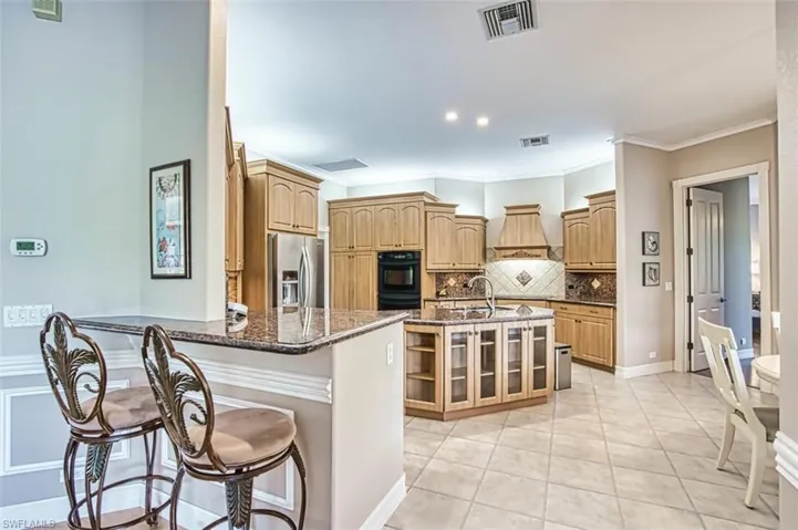 Kitchen featuring a breakfast bar, stainless steel appliances, island, double oven.