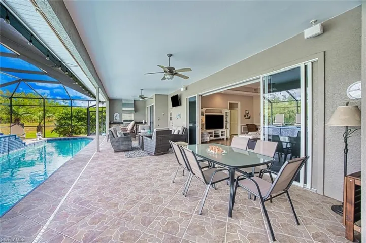 View of patio / terrace with ceiling fans, an outdoor living space, outdoor dining area, an outdoor pool & spa , and a lanai