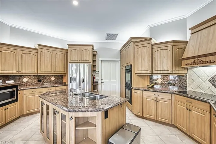 Kitchen featuring  excellent work space, island with sink, and light tile flooring