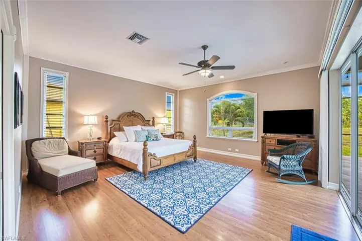 Primary bedroom with sliding doors to pool area.  Tall ceilings luxury vinyl flooring