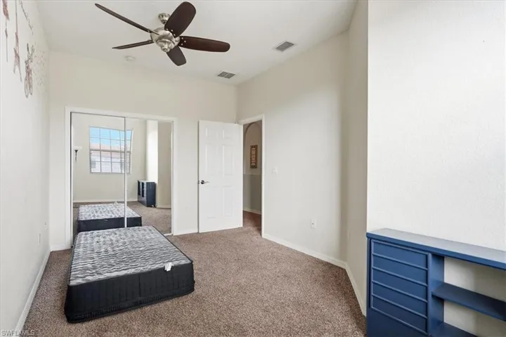 Bedroom featuring carpet, ceiling fan, and a closet