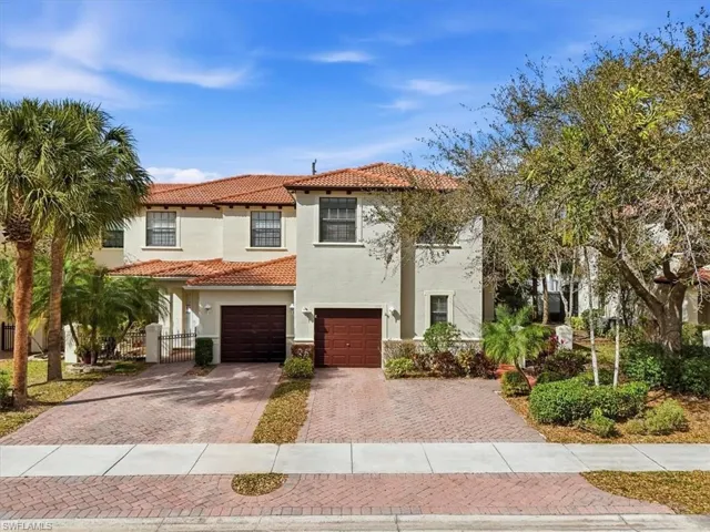 Mediterranean / spanish-style home featuring driveway, stucco siding, an attached garage, and a tile roof