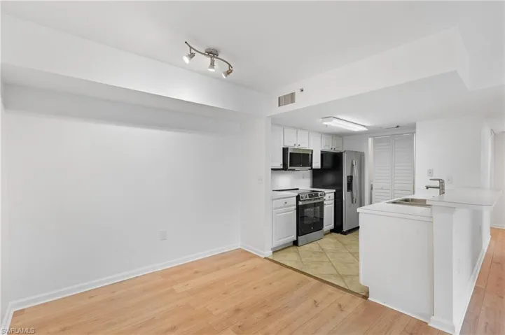 Kitchen featuring white cabinetry, sink, light hardwood / wood-style flooring, and stainless steel appliances