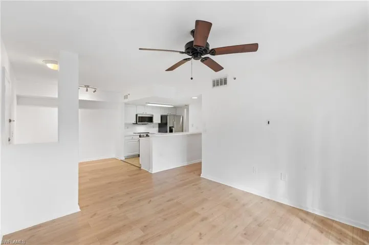 Unfurnished living room featuring ceiling fan and light wood-type flooring