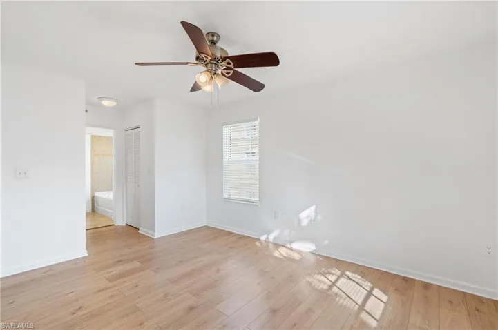 Empty room with ceiling fan and light hardwood / wood-style flooring