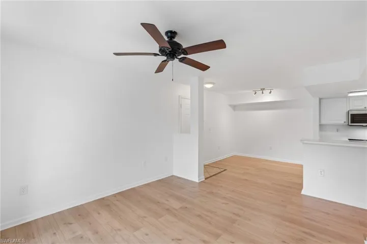 Unfurnished living room with ceiling fan and light hardwood / wood-style flooring