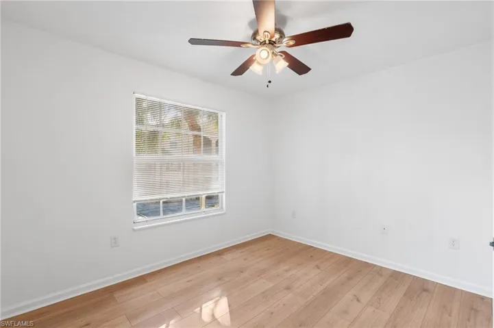 Unfurnished room with ceiling fan and light wood-type flooring