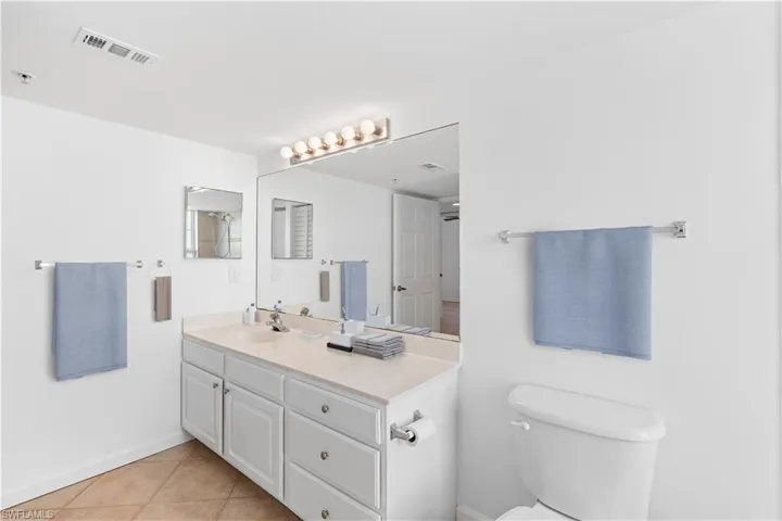 Bathroom with visible vents, baseboards, toilet, tile patterned floors, and vanity, Virtually Staged