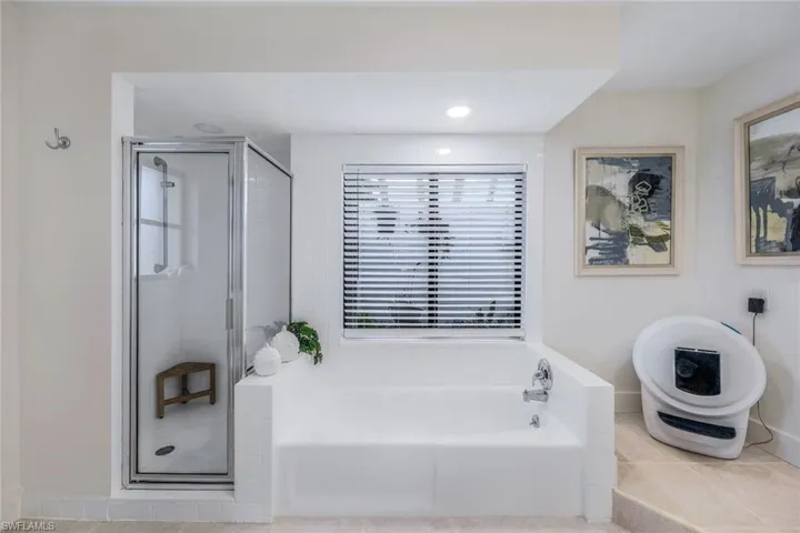 Bathroom with tile flooring and shower with separate bathtub