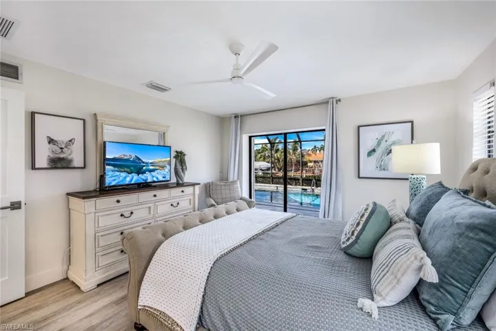 Bedroom featuring light hardwood / wood-style floors, ceiling fan, and access to exterior