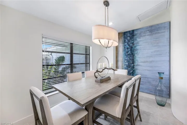 Dining space featuring vaulted ceiling and light tile floors