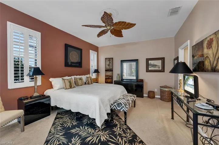 Bedroom with multiple windows, carpet floors, and ceiling fan