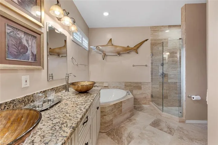 Bathroom featuring vanity and separate shower and tub