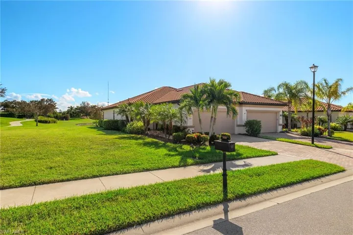 Mediterranean villa featuring a large side yard and a two car attached garage