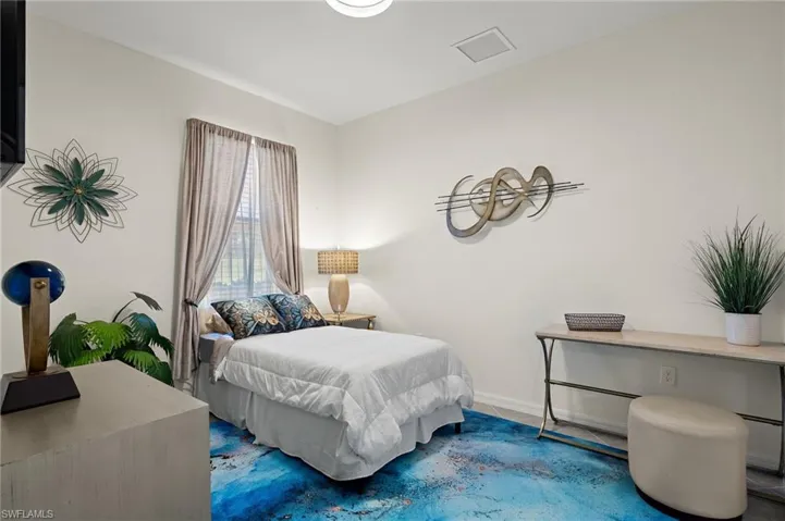 2nd fully furnished Guest bedroom with a desk and area rug.