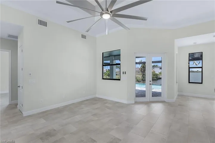 Unfurnished room with light tile floors, ceiling fan, french doors, and crown molding