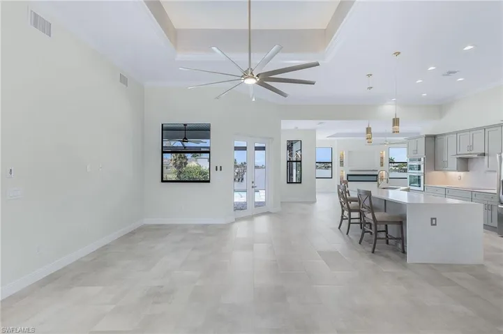 Kitchen with hanging light fixtures, a center island with sink, ceiling fan, a breakfast bar area, and sink