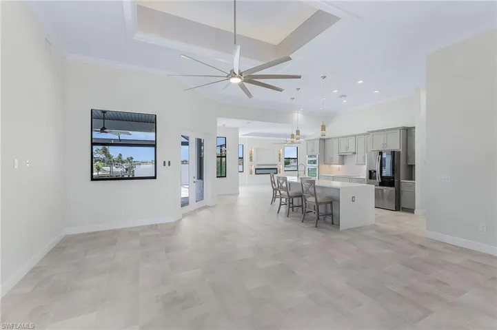 Kitchen featuring a center island, a kitchen breakfast bar, stainless steel fridge, and ceiling fan