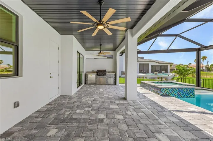 View of swimming pool with an in ground hot tub, a lanai, ceiling fan, and a patio area