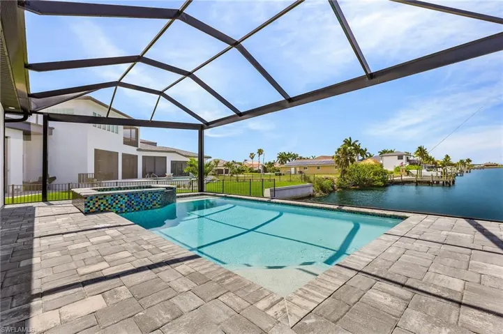 View of pool featuring a lanai, a water view, and a patio area