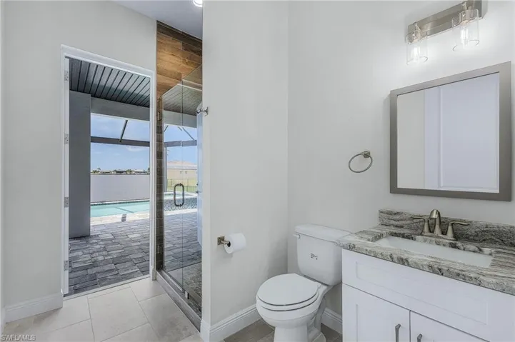 Bathroom with tile floors, toilet, walk in shower, and oversized vanity