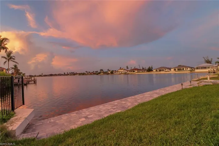 Dock area with a lawn and a water view