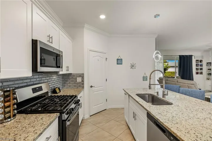 Kitchen featuring stainless steel appliances, a sink, and white cabinets