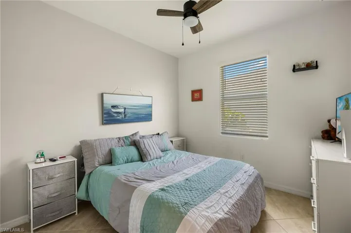 Bedroom with light tile patterned flooring, a ceiling fan, and baseboards