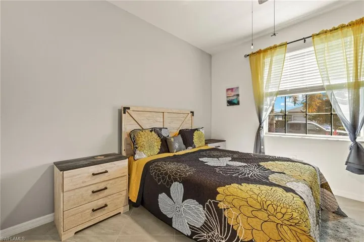 Bedroom with light tile patterned flooring and baseboards