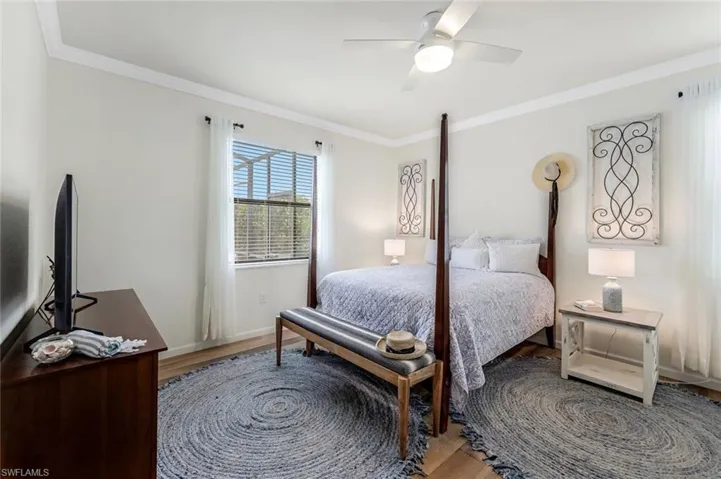 Bedroom featuring wood-type flooring, ceiling fan, and crown molding