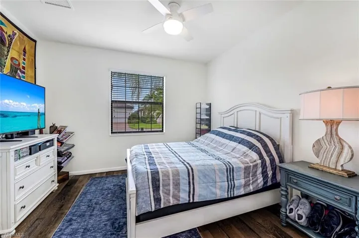 Bedroom with ceiling fan and dark wood-type flooring