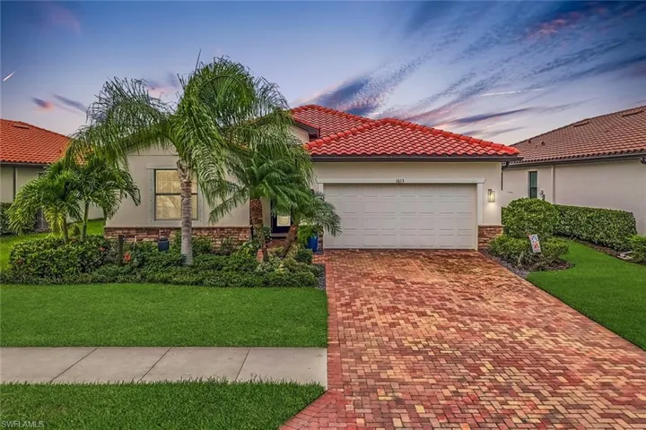 Mediterranean / spanish-style house with a lawn and a garage