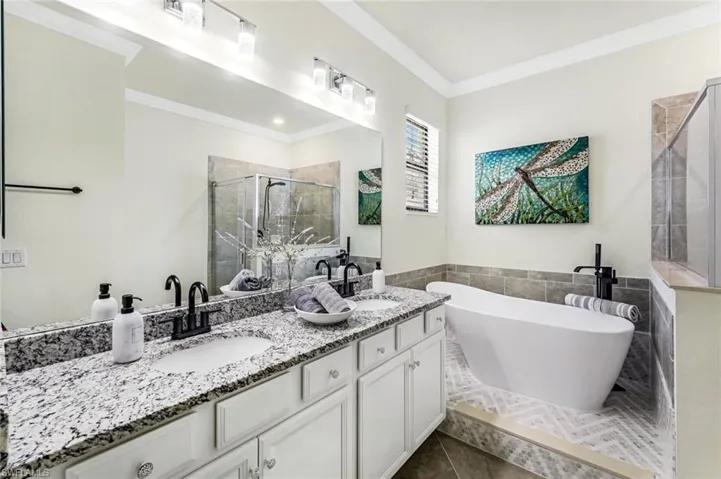 Bathroom with independent shower and bath, vanity, ornamental molding, and tile patterned floors