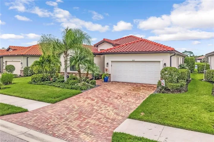 Mediterranean / spanish home featuring a front lawn and a garage