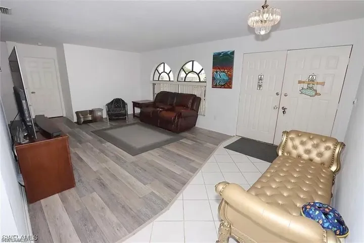Living room with light wood-style floors and a chandelier