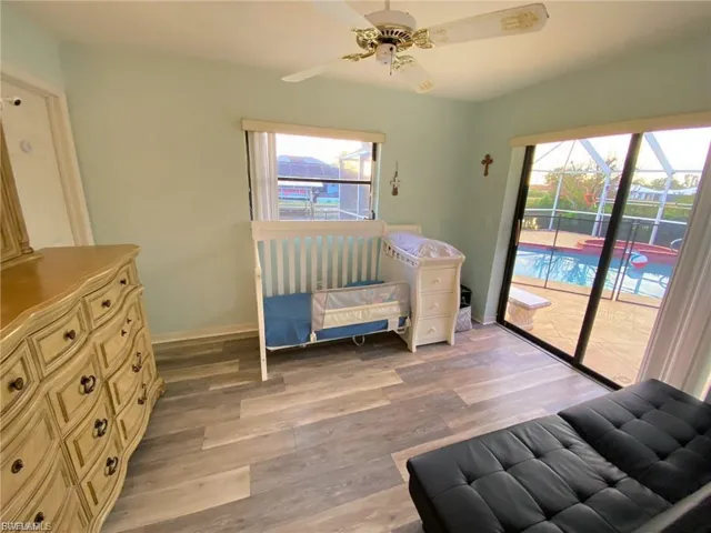 Bedroom featuring light wood finished floors, access to exterior, and multiple windows