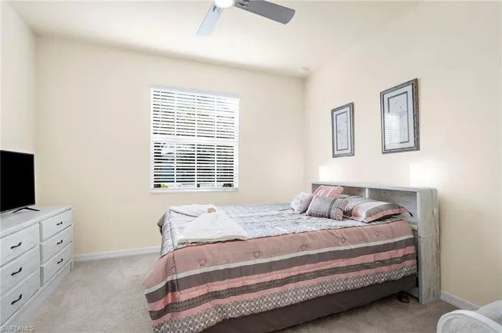 Carpeted bedroom featuring ceiling fan
