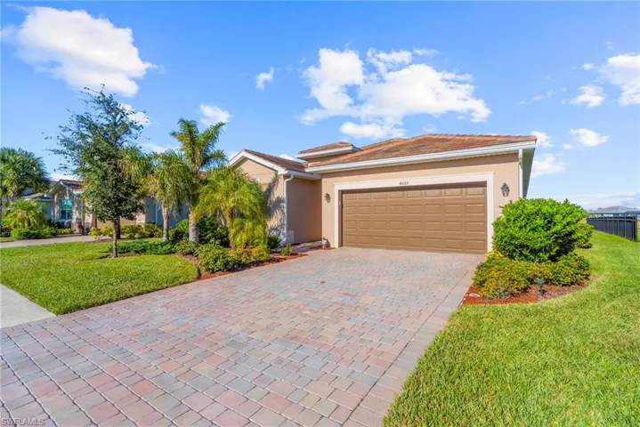 Single story home with a garage and a front lawn