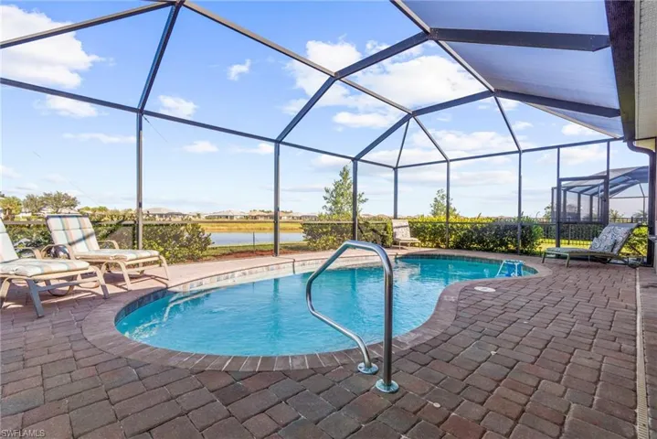 View of pool with a water view, a patio area, and a lanai
