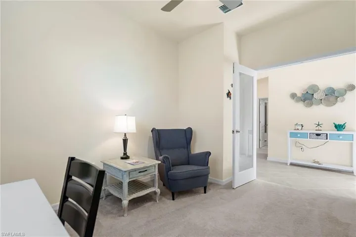 Living area with french doors, light colored carpet, and ceiling fan