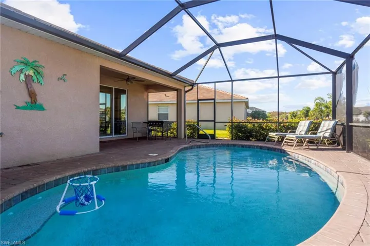 View of pool featuring a patio and glass enclosure