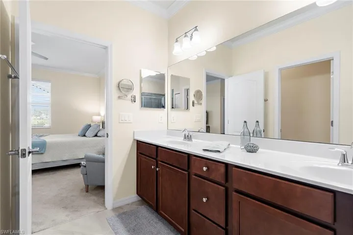 Bathroom featuring tile patterned floors, vanity, and crown molding